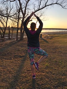 Louellen doing yoga at sunset overlooking the lake at Little Elm Park.