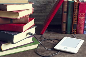 Books and an ereader on a table.